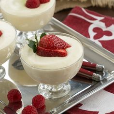 two desserts with strawberries are on a silver tray