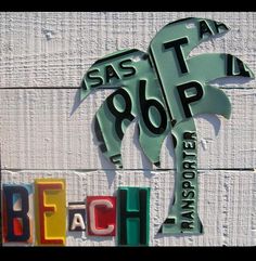 there is a sign that says beach and palm tree on the side of a building