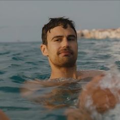 a man swimming in the ocean with his head above water