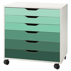 a green and white dresser with four drawers on wheels, against a white background that has black dots in the bottom drawer