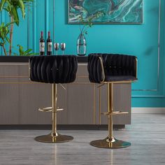 two black and gold bar stools in front of a blue wall