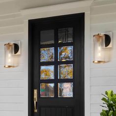 a black front door with two lights on the side