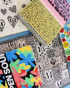 several notebooks with designs on them are lined up next to each other in different colors