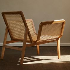 a wooden chair sitting on top of a hard wood floor next to a white wall