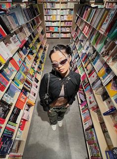 a woman standing in the middle of a book store aisle