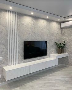 a large flat screen tv mounted to the side of a wall in a living room