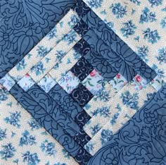 the blue and white quilt is laying on top of each other's sides,