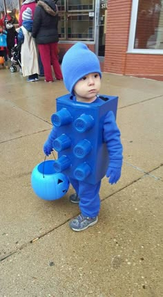 a little boy in a blue suit with lots of buttons on his chest and legs