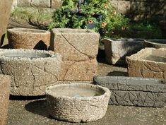 several cement bowls are sitting on the ground