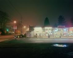 an empty gas station at night with the lights on and no one in it yet