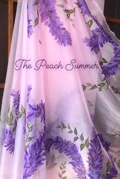 the beach summer cover up has purple flowers on it and is in front of a window