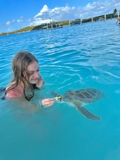 a woman in the water with a turtle