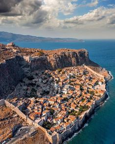 an aerial view of a small village on the edge of a cliff overlooking the ocean