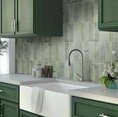 a kitchen with green cabinets and white counter tops, including a dishwasher in the center