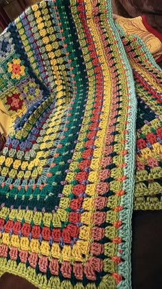 a crocheted blanket is sitting on a couch