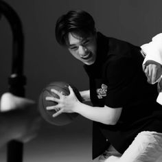 a man holding a basketball in his right hand while another person holds the ball behind him