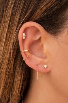 a woman's ear with three different types of piercings