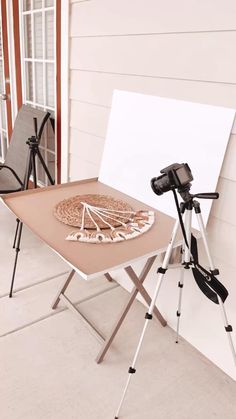 a pizza sitting on top of a wooden table next to a white board and tripod