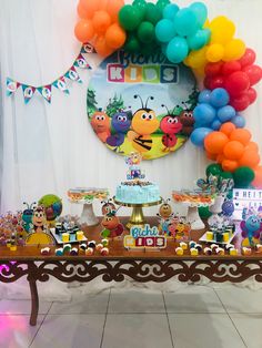 a table topped with lots of cake and balloons