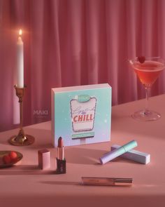 a table topped with lipstick and candles next to a card on top of a table