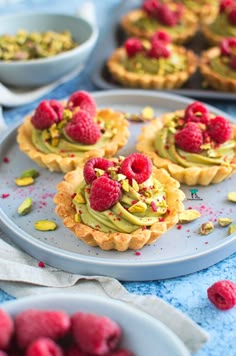 raspberry and pistachio tarts on a plate