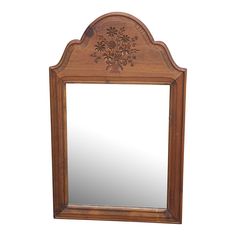 a wooden mirror sitting on top of a white wall