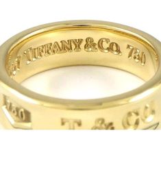 This stunning Gold Tiffany & Co. ring is a vintage piece from the Tiffany 1837 collection. Crafted from 18k yellow gold, the ring features a round shape and a 6mm wide band. The ring is signed by the maker and is a perfect choice for special occasions like weddings, graduations, and anniversaries. The ring is not customized and does not feature any stones, making it a great choice for those who appreciate beauty, luxury, and art. The ring is a perfect gift for Mother's Day, Father's Day, Christmas, and Valentine's Day. The vintage design of the ring is inspired by Viking and art themes, and the skeletons and skulls theme adds a touch of luck and love. This ring is a must-have for anyone who wants to add a touch of elegance and style to their collection. Tiffany And Co Signet Ring, Tiffany Sixteen Stone Ring, Tiffany 1837 Ring, Tiffany And Co 1837 Ring, Gold Tiffany, 1960s Tiffany & Co. Jewelry, Wide Ring, Wide Rings, The Maker