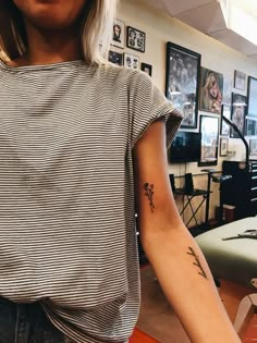 a woman with a flower tattoo on her arm in an office setting, looking at the camera