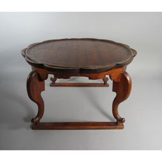 an old wooden table with two circular trays on the top and one at the bottom