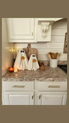 two towels are sitting on the counter in front of some candles and other kitchen items