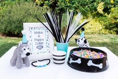 a dog themed birthday party is set up on a white table with black and white decor