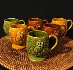 six coffee cups sitting on top of a woven place mat