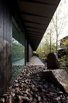 the walkway is lined with large rocks and boulders, leading to an outdoor deck area