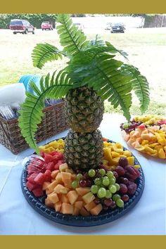 a pineapple sits on top of a platter of fruit