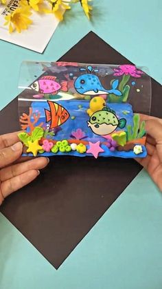 someone is holding a plastic case with fish and sea animals on it