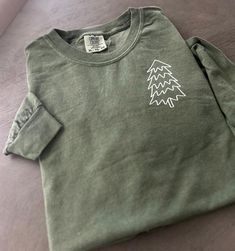 CANCELLATION CAN ONLY BE DONE BETWEEN 24 HOURS AFTER ORDERING  Emroidered tree shirt, embroidered Christmas tree, trendy Christmas tree These beautifully designed shirts and sweatshirts will make your day  a little extraordinary and meaningful.  Made out of good quality cotton and it feels so soft and nice. Please see our size chart and colors (available colors and sizes may vary, please reach us to find out currently available colors and sizes). The print colors are red, white and black, other Embroidered Christmas Sweatshirt, Christmas Tree Minimalist, Christmas Shirts Vinyl, Christmas Tree Outline, Embroidered Christmas Tree, Embroidered Tree, Designed Shirts, Have A Happy Holiday, Minimalist Christmas Tree