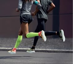 a man and woman running down the street with their feet on each other's legs