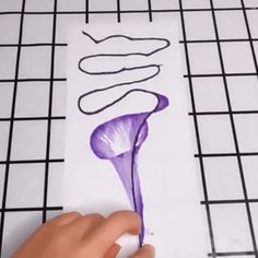 someone is drawing flowers on a piece of paper