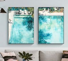 two paintings hanging on the wall above a couch in a living room next to a pool