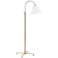 a floor lamp with a white shade on the top and an iron base, standing upright