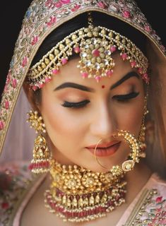 a woman wearing a bridal outfit and jewelry