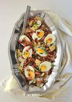 an egg and bacon salad is served in a serving dish with a fork on the side