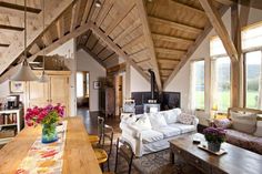 a living room filled with furniture next to a kitchen and dining room table in front of large windows