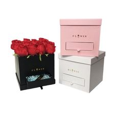 two boxes with roses in them sitting next to each other