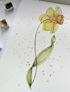 a watercolor painting of a yellow flower on white paper with gold flecks