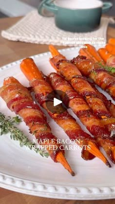 bacon wrapped carrots on a white plate