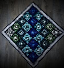 a blue, green and white rug on top of a wooden floor