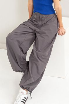 Get ready for some cute strutin' in these Street Style Parachute Pants. Featuring a high waist with a drawstring and button closure, plus roomy pockets and adjustable ankles, you'll be both comfy and stylish. Perfect for a laid-back day or a casual night out. Available in Gray and Black! 100% Nylon DZ24C114 Casual Night Out, Back Day, Utility Pants, Black Media, Get Ready, Parachute Pants, Black Pants, Night Out, High Waist