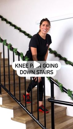 a woman sitting on top of a set of stairs next to a banister with christmas garland