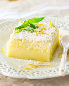 a white plate topped with a piece of cake covered in whipped cream and lemon zest